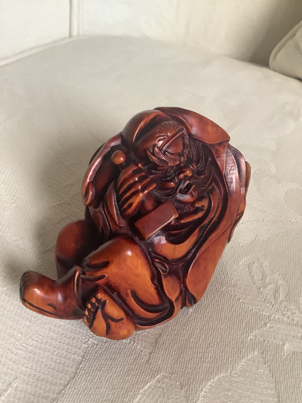 A Japanese hand-carved wooden figure depicting a bearded man in flowing robes with a smooth polished brown finish. View VI