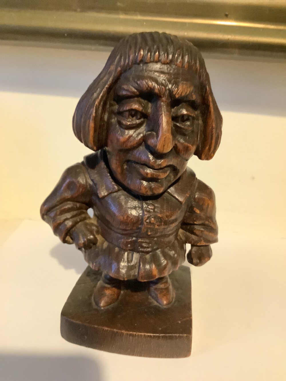 A dark carved wooden statuette depicting Oliver Cromwell standing on an integrated wooden base. View V