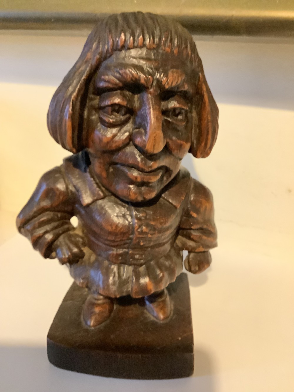 A dark carved wooden statuette depicting Oliver Cromwell standing on an integrated wooden base. View II