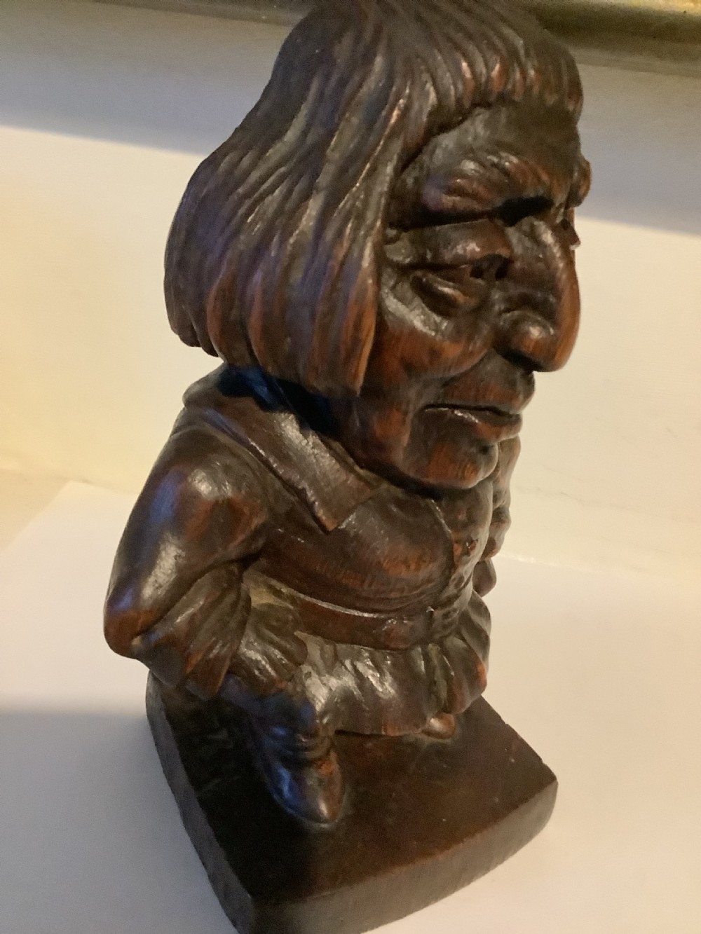 A dark carved wooden statuette depicting Oliver Cromwell standing on an integrated wooden base. View III