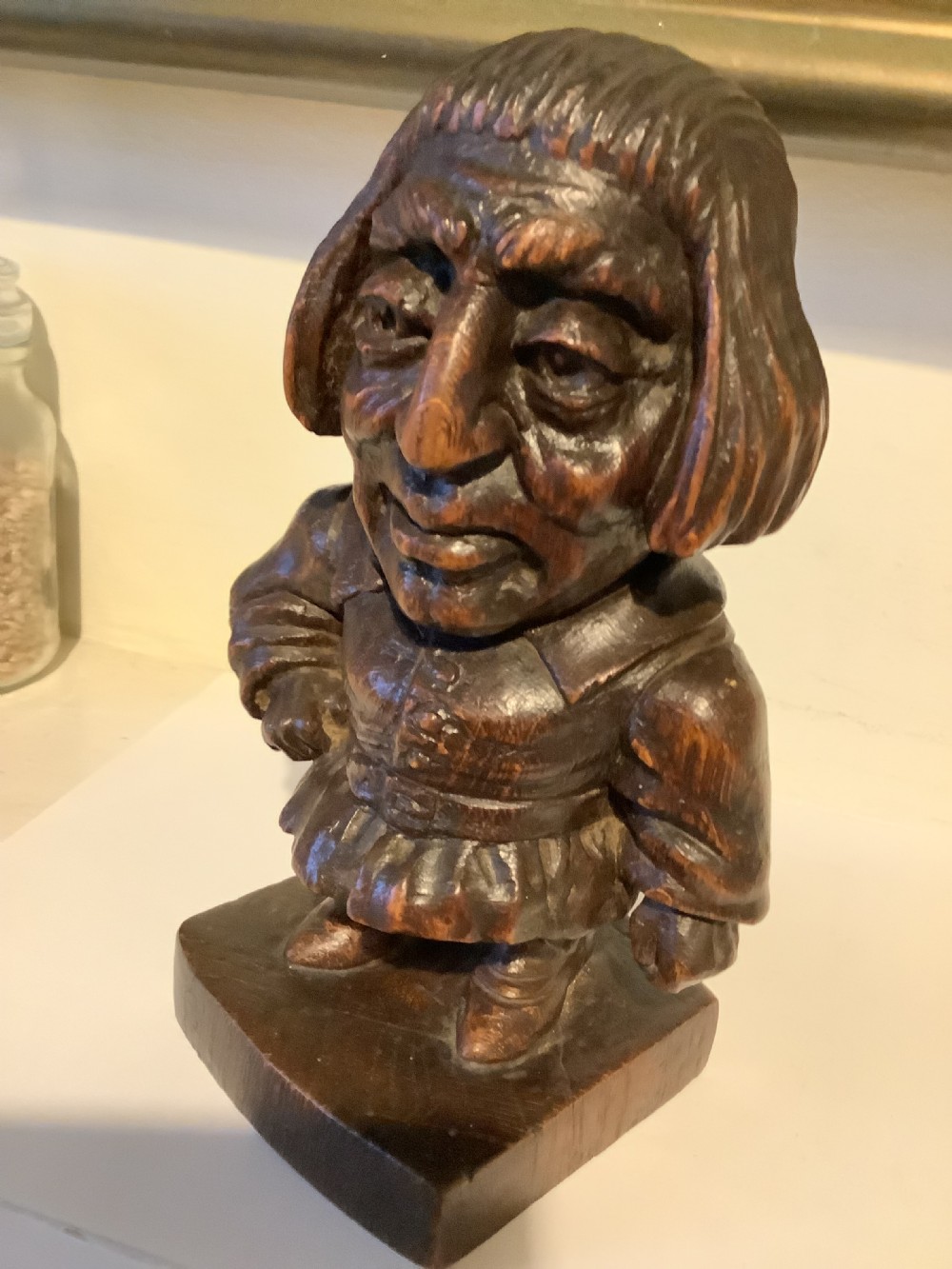 A dark carved wooden statuette depicting Oliver Cromwell standing on an integrated wooden base. View IV