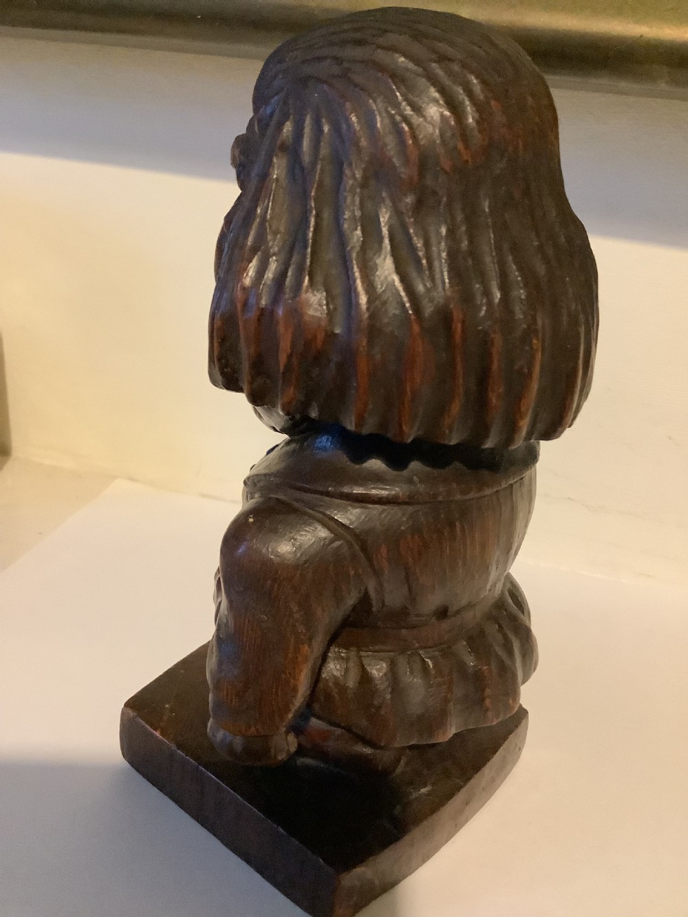 A dark carved wooden statuette depicting Oliver Cromwell standing on an integrated wooden base. View VI