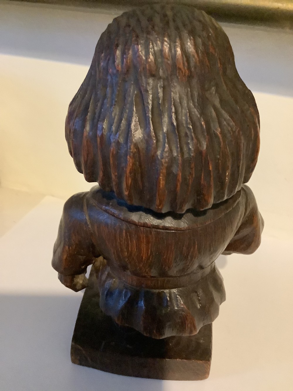 A dark carved wooden statuette depicting Oliver Cromwell standing on an integrated wooden base. View VII