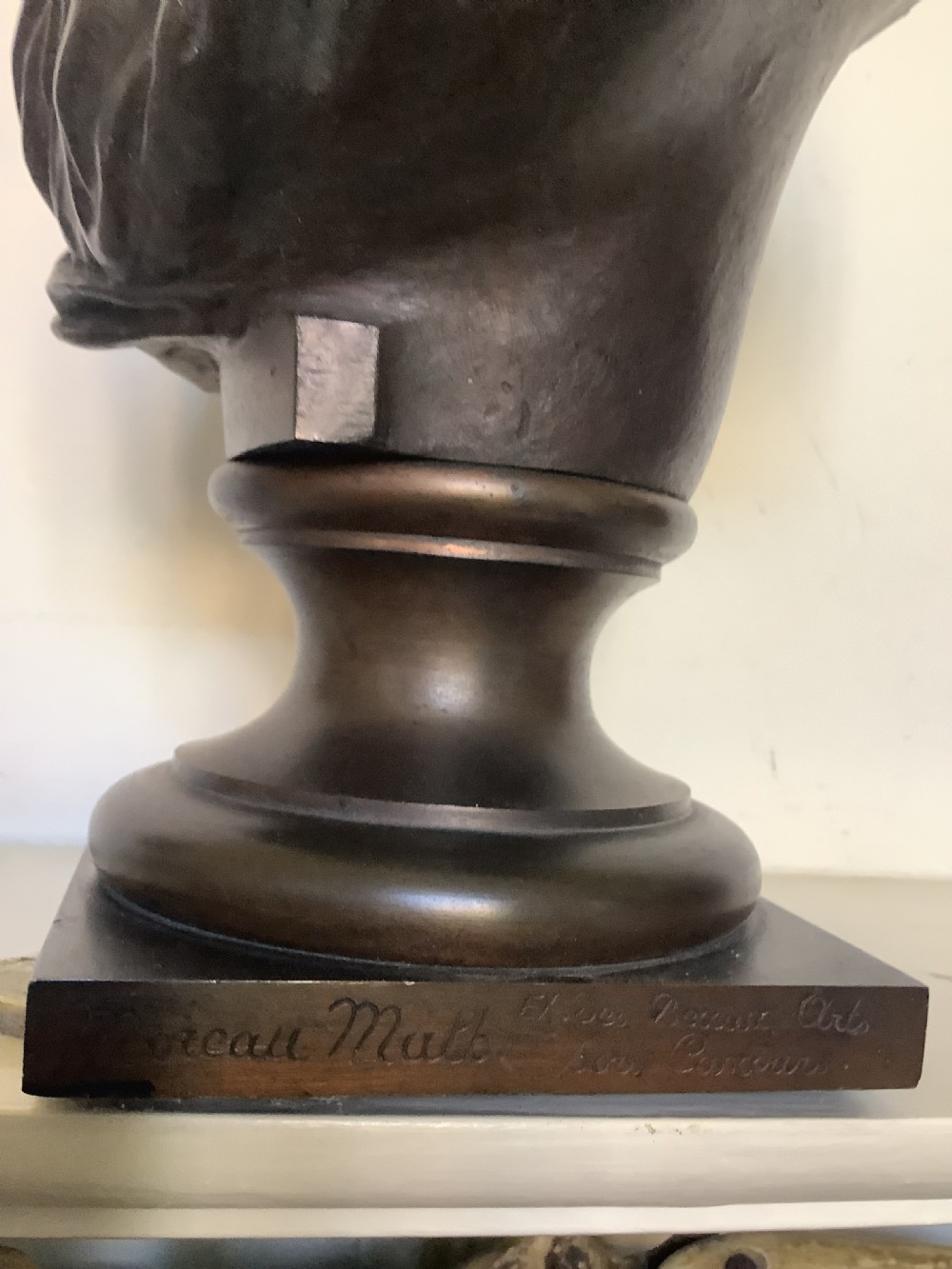 A patinated dark bronze bust depicting a classical Roman emperor with short curled hair and a draped toga, mounted on a turned circular socle and square base. View VII