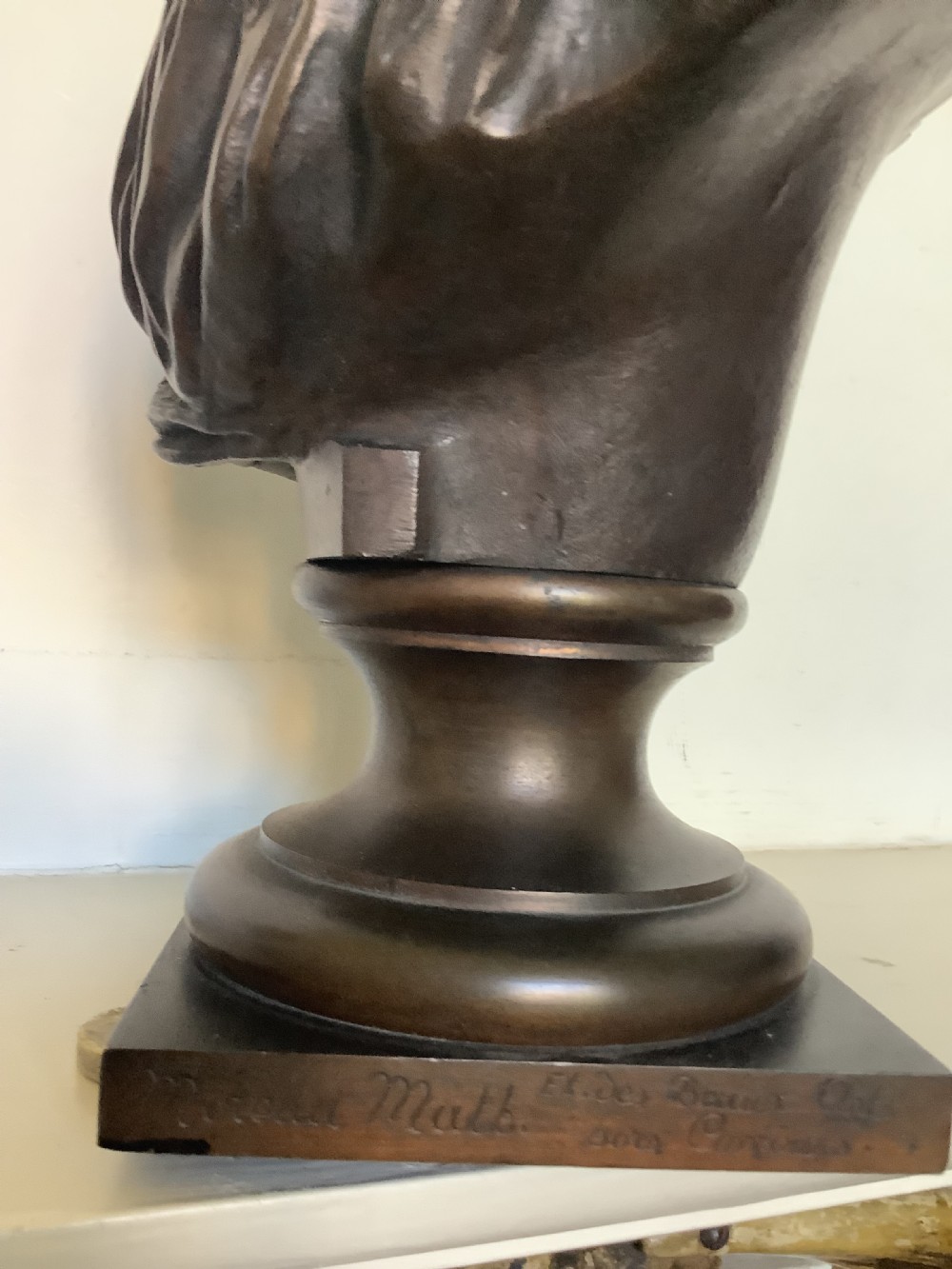 A patinated dark bronze bust depicting a classical Roman emperor with short curled hair and a draped toga, mounted on a turned circular socle and square base. View XI