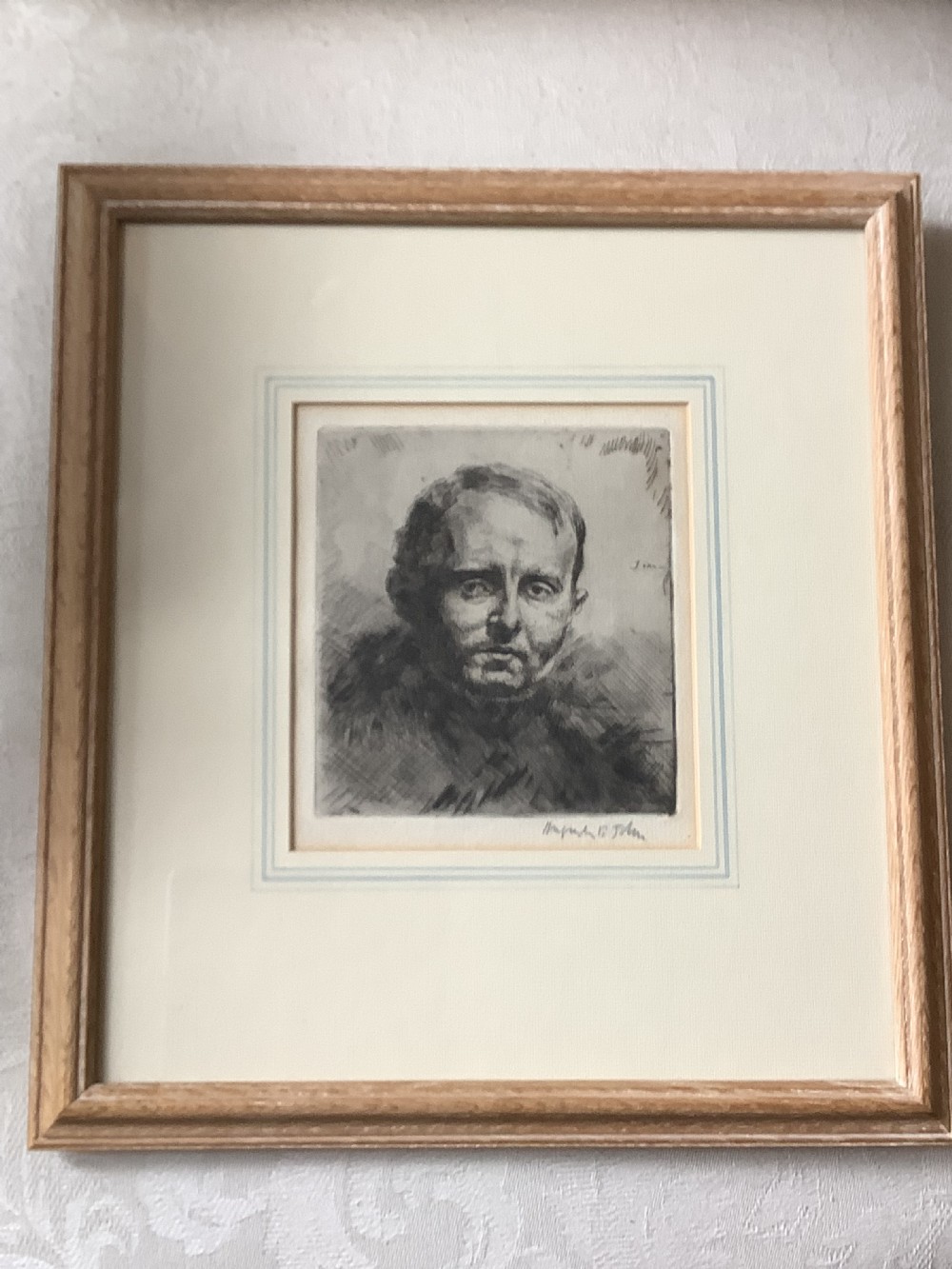 A framed monochrome portrait etching of a mans head executed with dense cross-hatching and signed in pencil beneath the plate mark. View IX