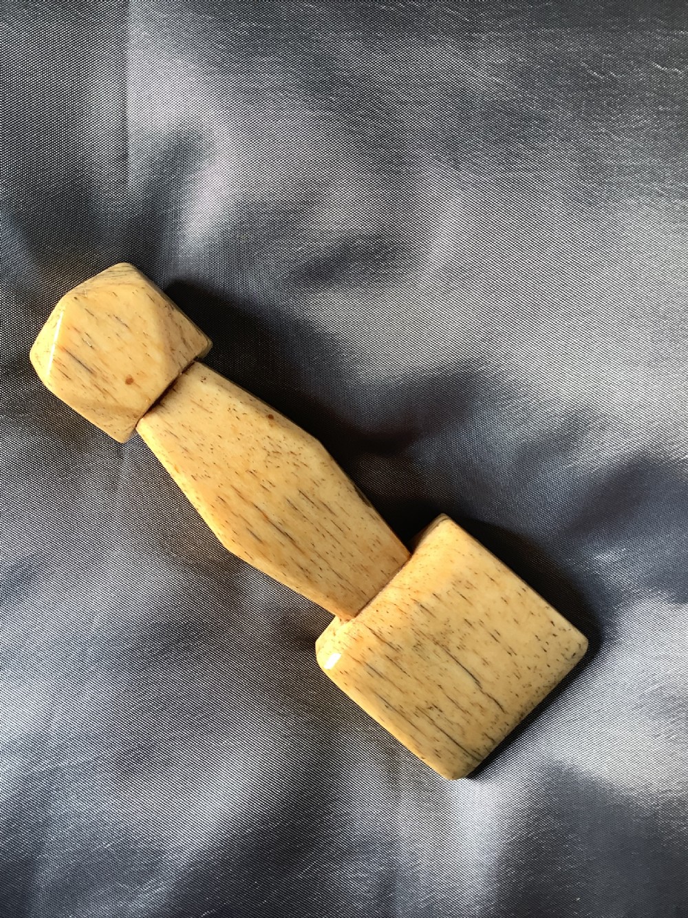 A hand-carved cream bone sailmakers seam rubber featuring a flattened blade base and a faceted geometric handle. View III