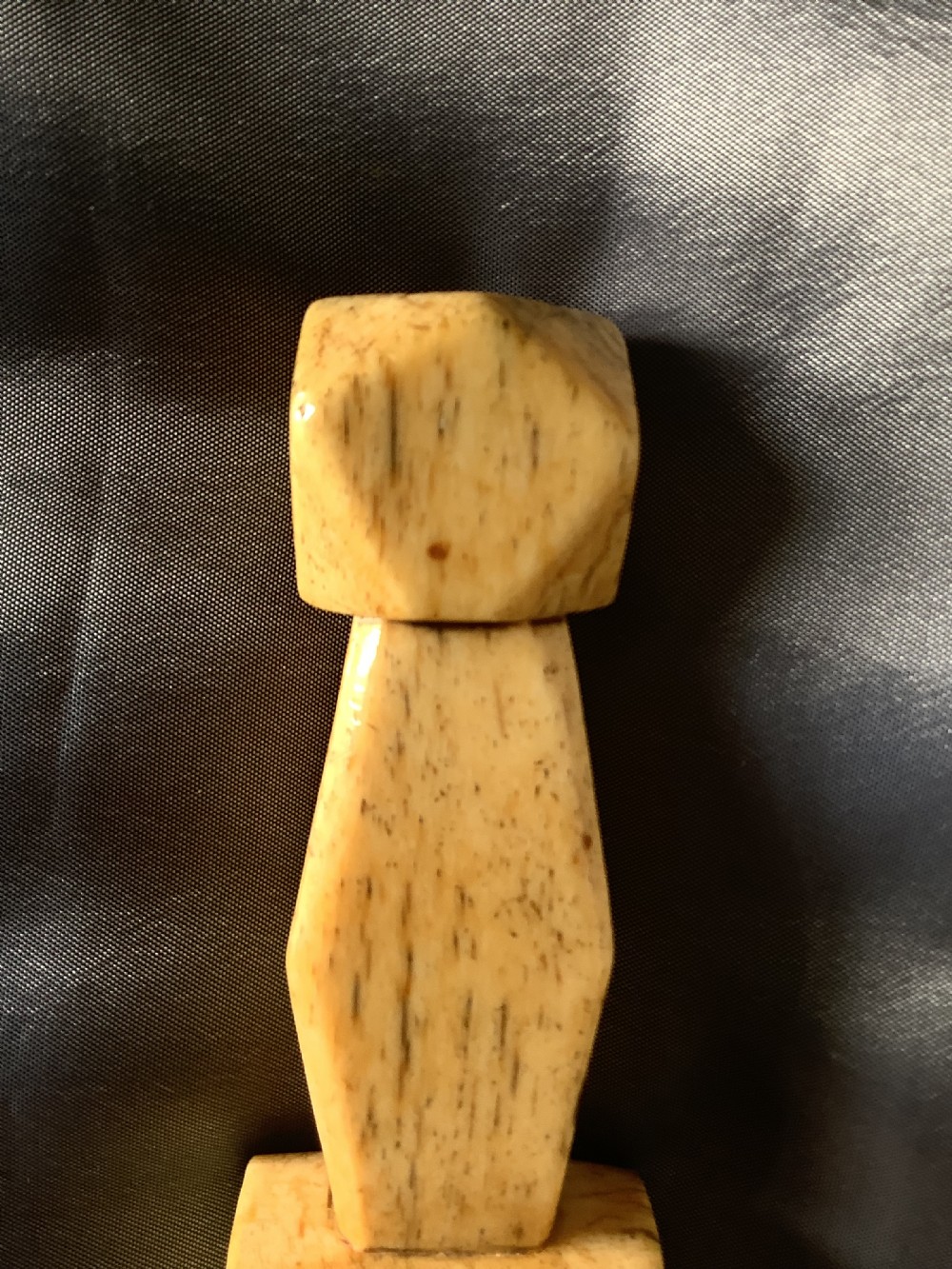 A hand-carved cream bone sailmakers seam rubber featuring a flattened blade base and a faceted geometric handle. View VII