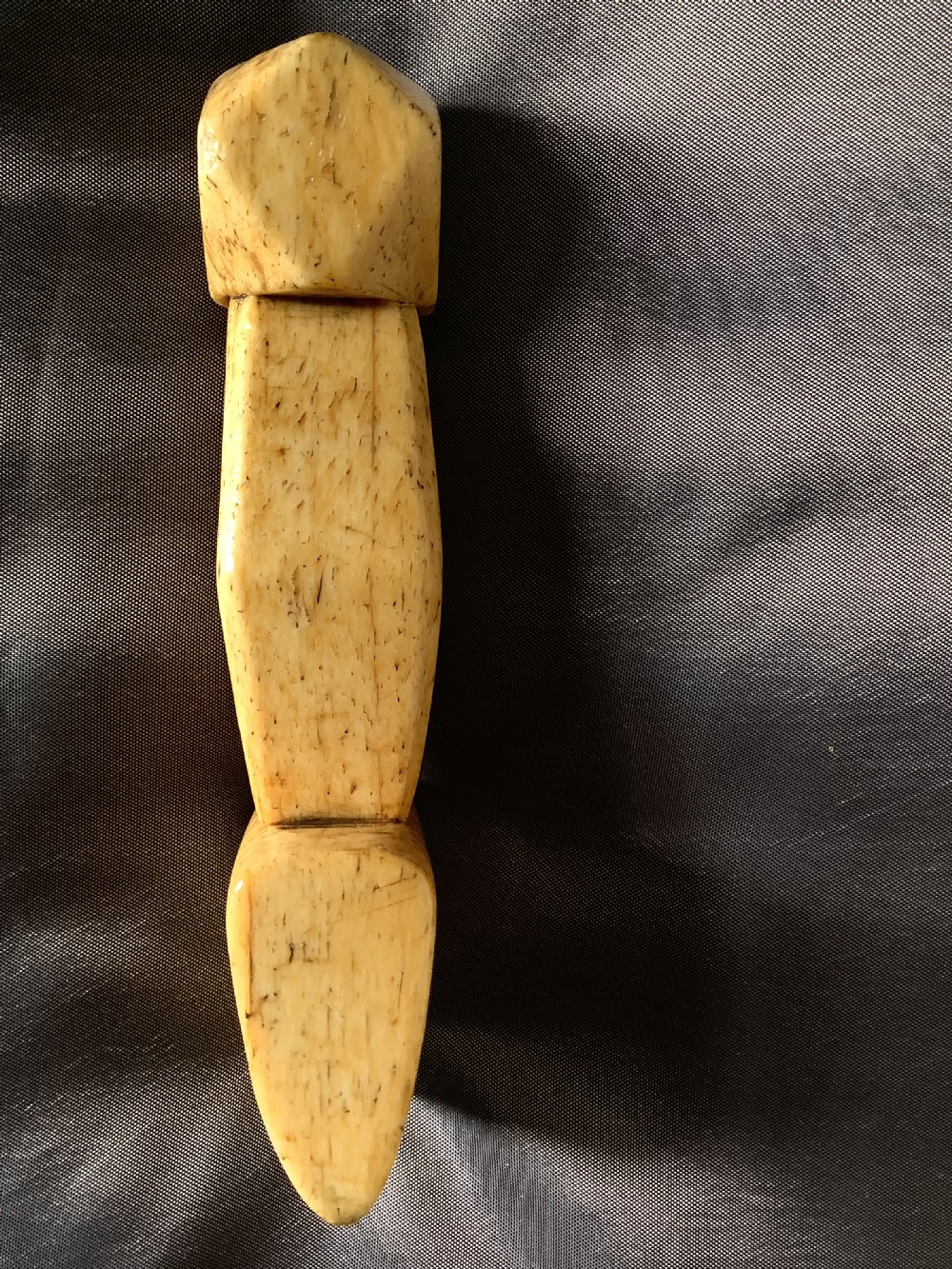 A hand-carved cream bone sailmakers seam rubber featuring a flattened blade base and a faceted geometric handle. View VIII