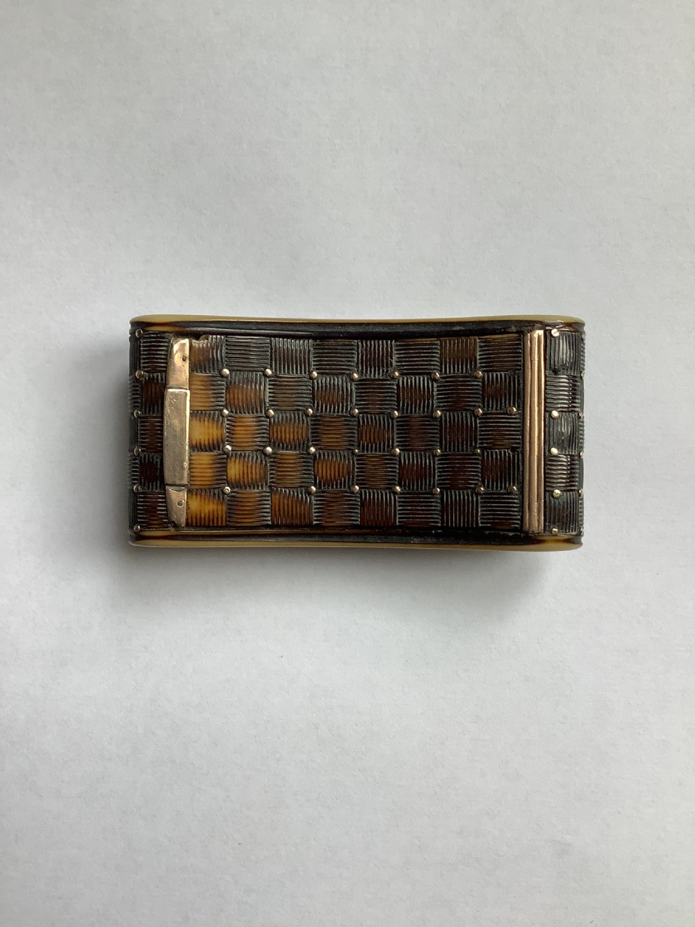 A rectangular carved horn snuff box featuring a basketweave surface pattern, metal pique studs, and subtly curved sides. View VI
