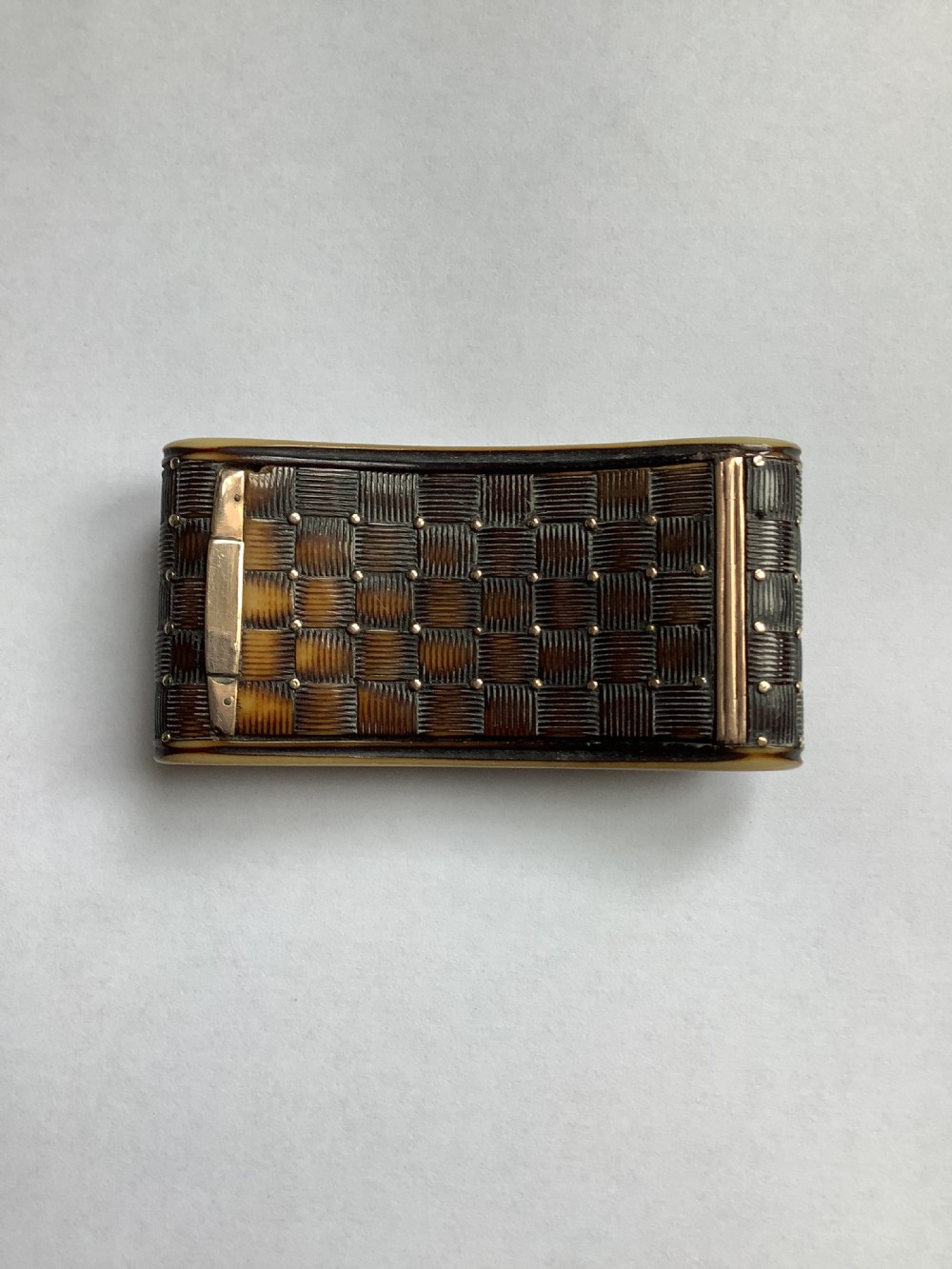 A rectangular carved horn snuff box featuring a basketweave surface pattern, metal pique studs, and subtly curved sides. View VII