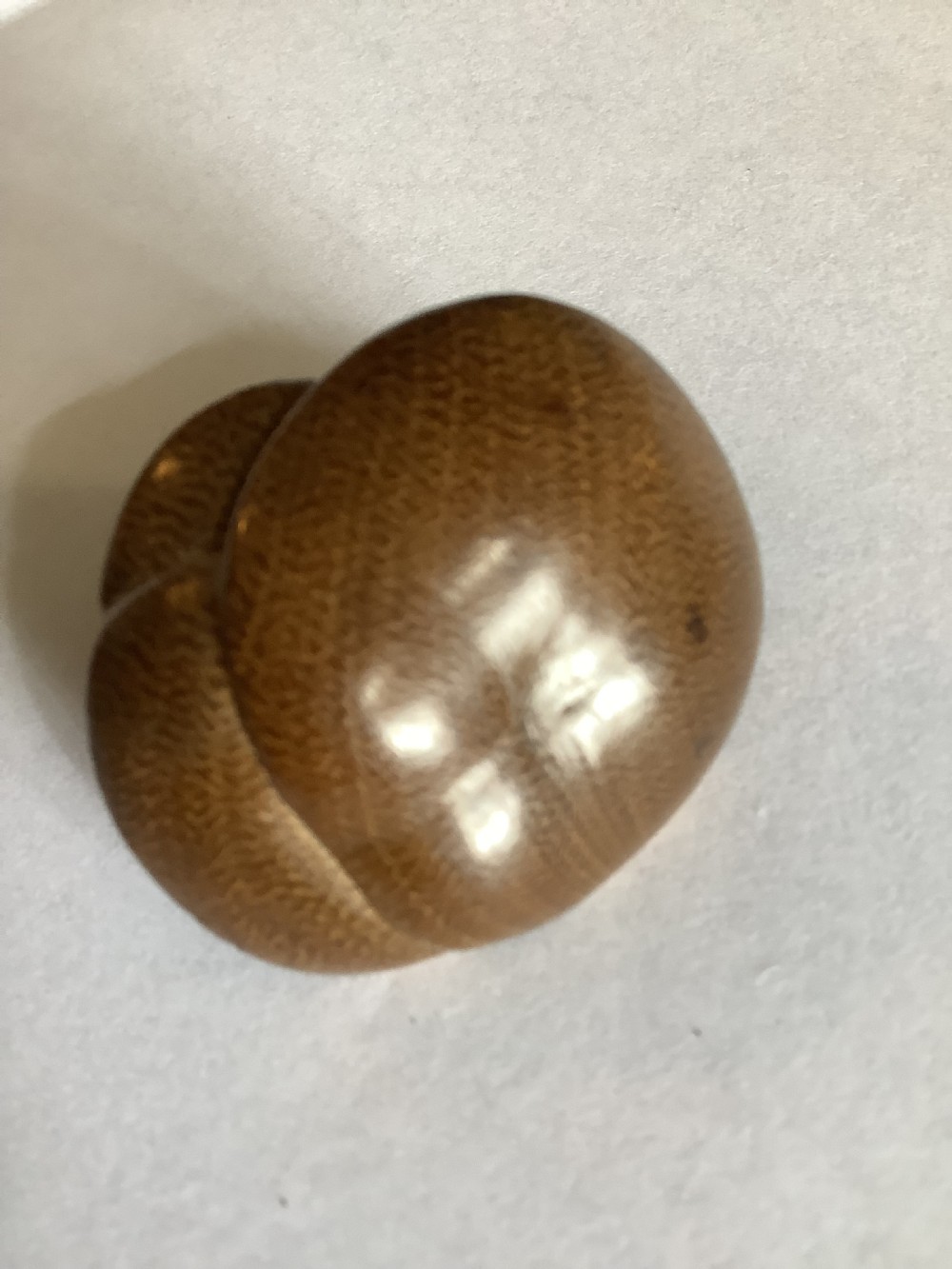 A small, finely carved wooden netsuke depicting a naturalistic cluster of mushrooms with detailed underside gills. View II