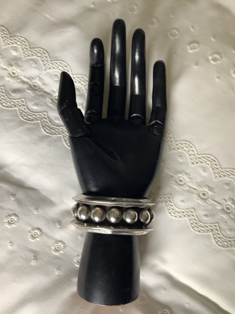 A wide sterling silver cuff bracelet featuring a central row of raised spherical studs bordered by raised outer rims.