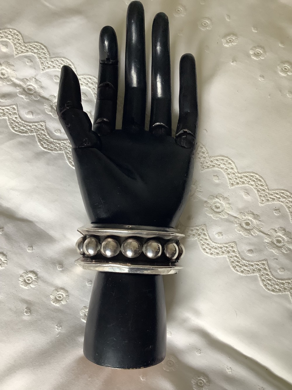A wide sterling silver cuff bracelet featuring a central row of raised spherical studs bordered by raised outer rims. View II