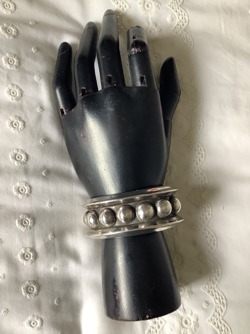 A wide sterling silver cuff bracelet featuring a central row of raised spherical studs bordered by raised outer rims. View IV