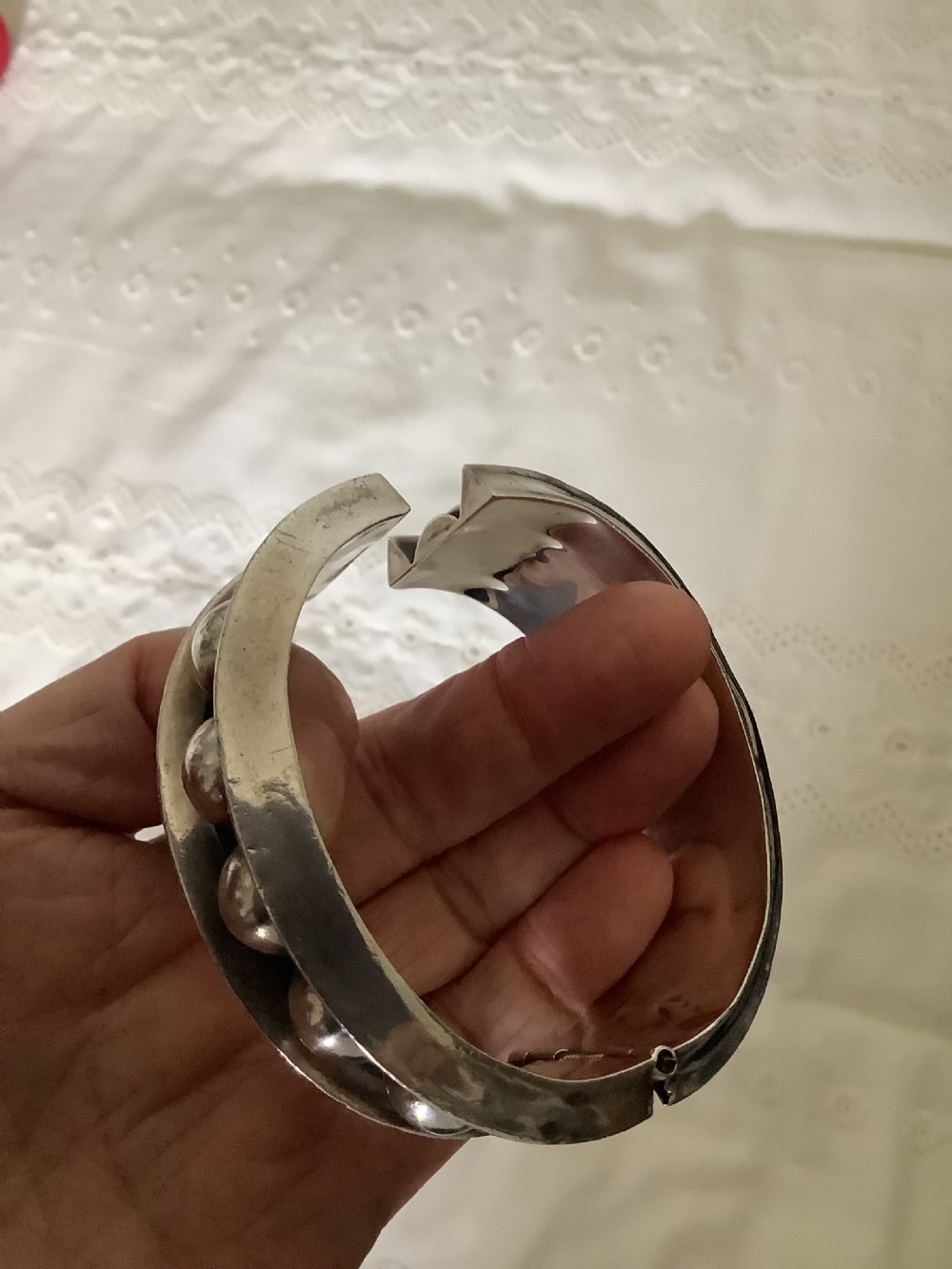 A wide sterling silver cuff bracelet featuring a central row of raised spherical studs bordered by raised outer rims. View VII