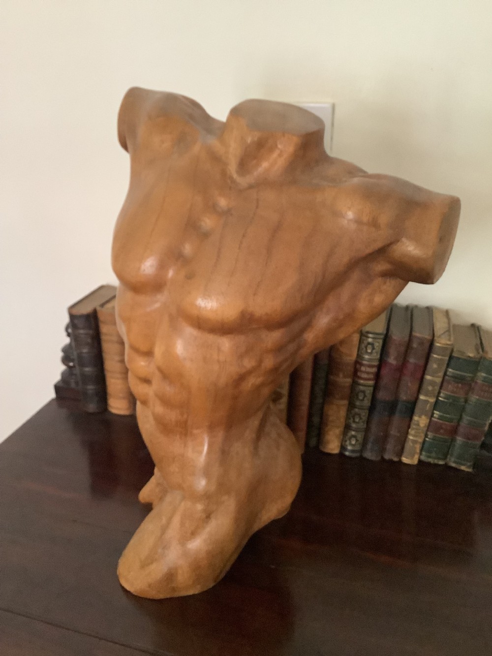 A three-dimensional carved hardwood sculpture depicting a classical male torso with defined muscle structure and a smooth polished finish. View IV