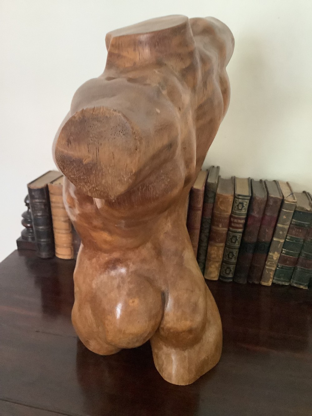 A three-dimensional carved hardwood sculpture depicting a classical male torso with defined muscle structure and a smooth polished finish. View III