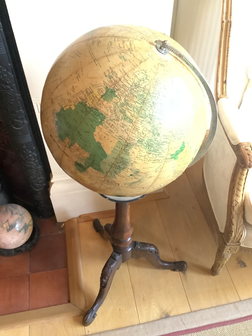 A terrestrial floor-standing globe mounted on a brass half-meridian, supported by a turned mahogany column with carved tripod cabriole legs. View III