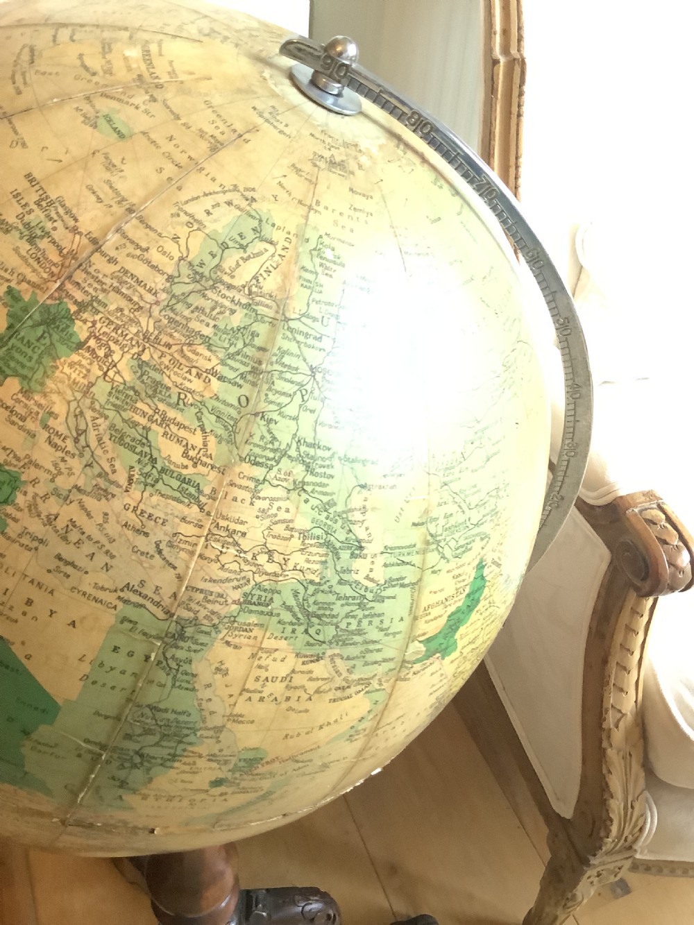 A terrestrial floor-standing globe mounted on a brass half-meridian, supported by a turned mahogany column with carved tripod cabriole legs. View VI