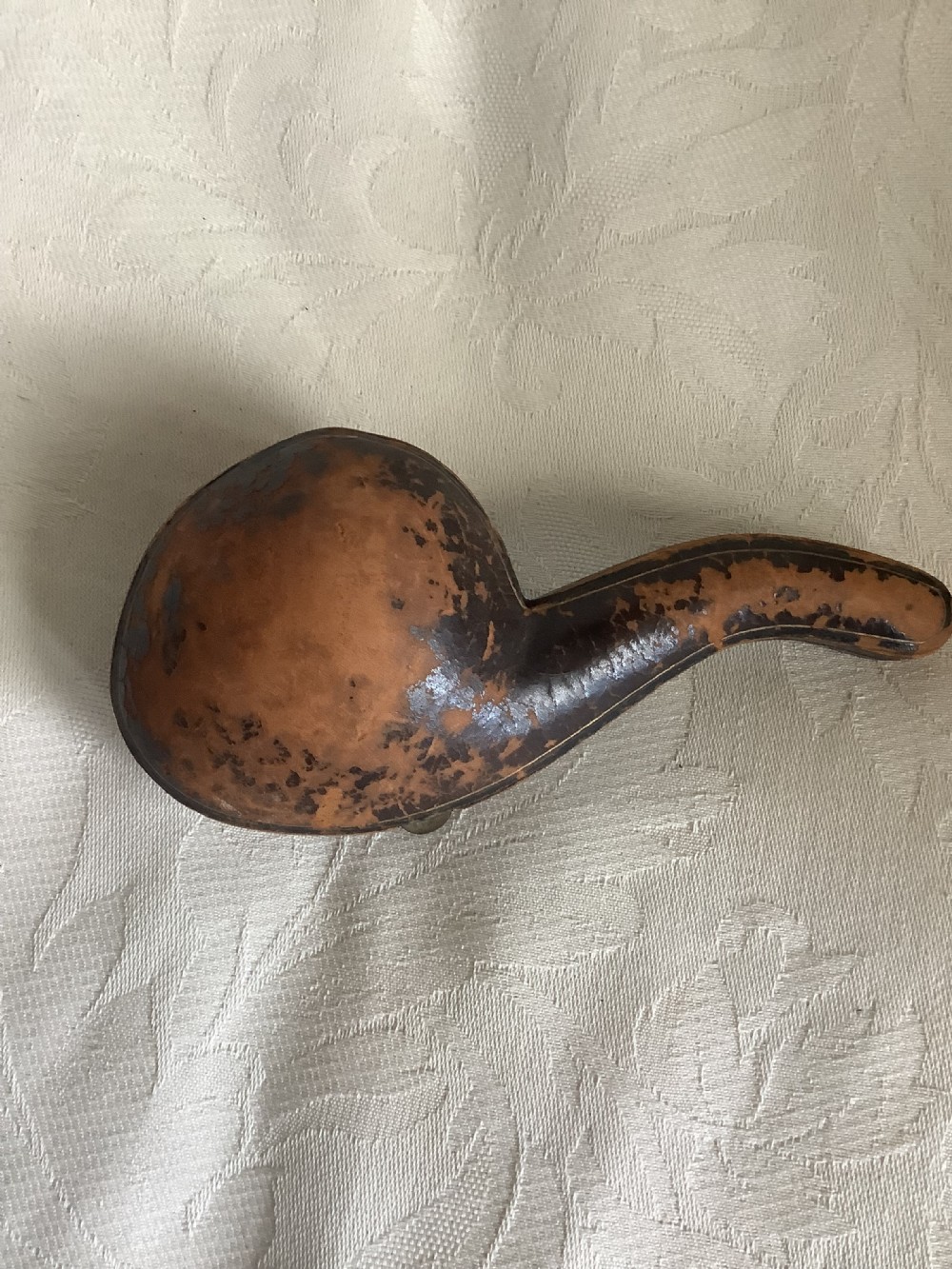 A hand-carved meerschaum smoking pipe featuring a detailed lion head bowl with an open mouth and a translucent amber-coloured curved stem. View VII