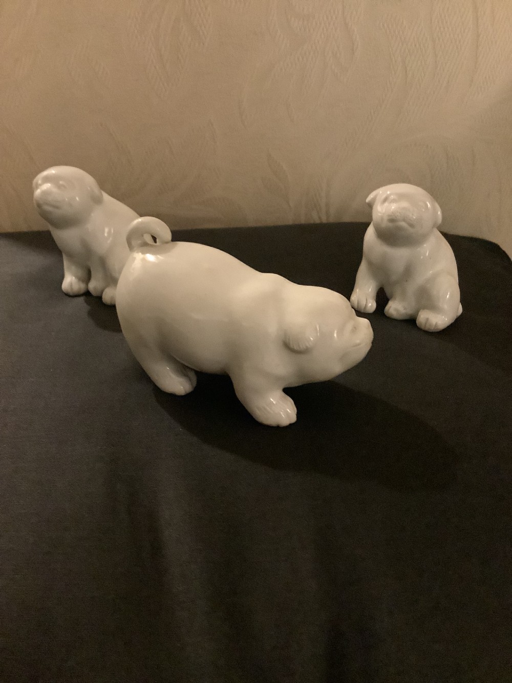 A set of three monochrome white glazed porcelain Japanese Hirado puppy figurines sculpted in seated and standing poses. View II