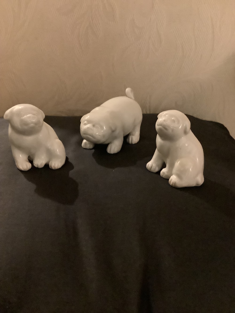 A set of three monochrome white glazed porcelain Japanese Hirado puppy figurines sculpted in seated and standing poses. View III
