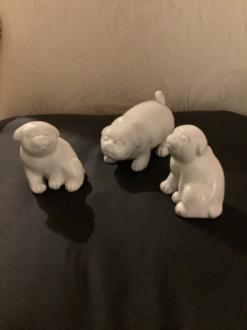 A set of three monochrome white glazed porcelain Japanese Hirado puppy figurines sculpted in seated and standing poses. View IV