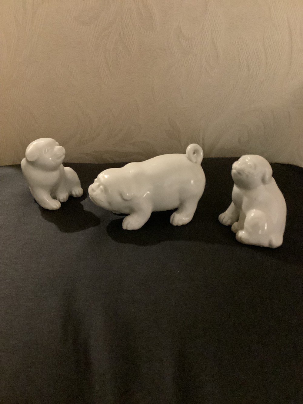 A set of three monochrome white glazed porcelain Japanese Hirado puppy figurines sculpted in seated and standing poses. View VI
