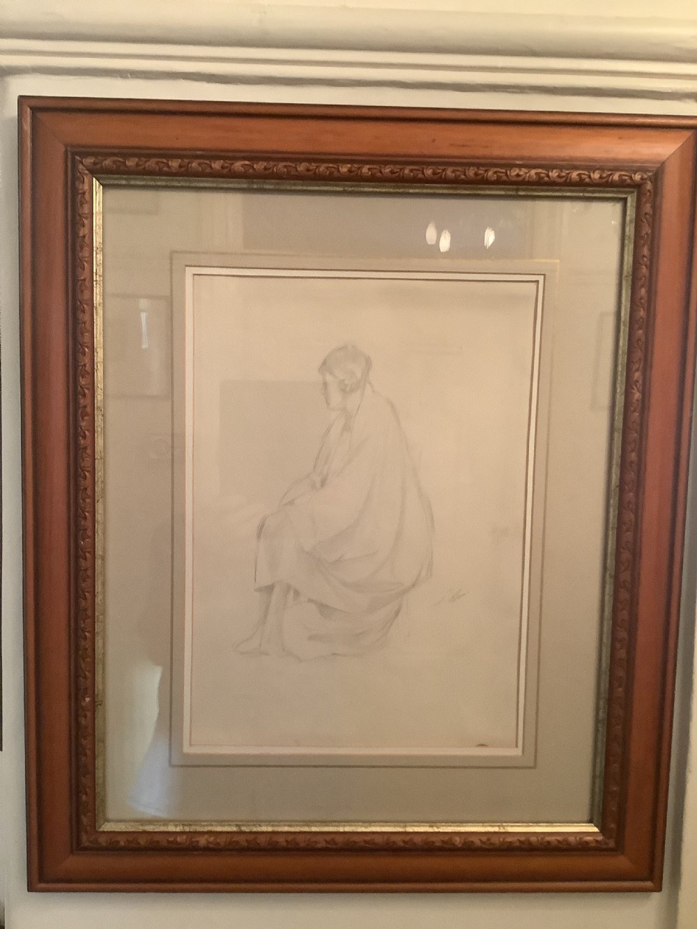 A framed monochrome pencil sketch depicting a seated draped female figure, presented in a neutral double mount within a moulded wooden frame. View IV