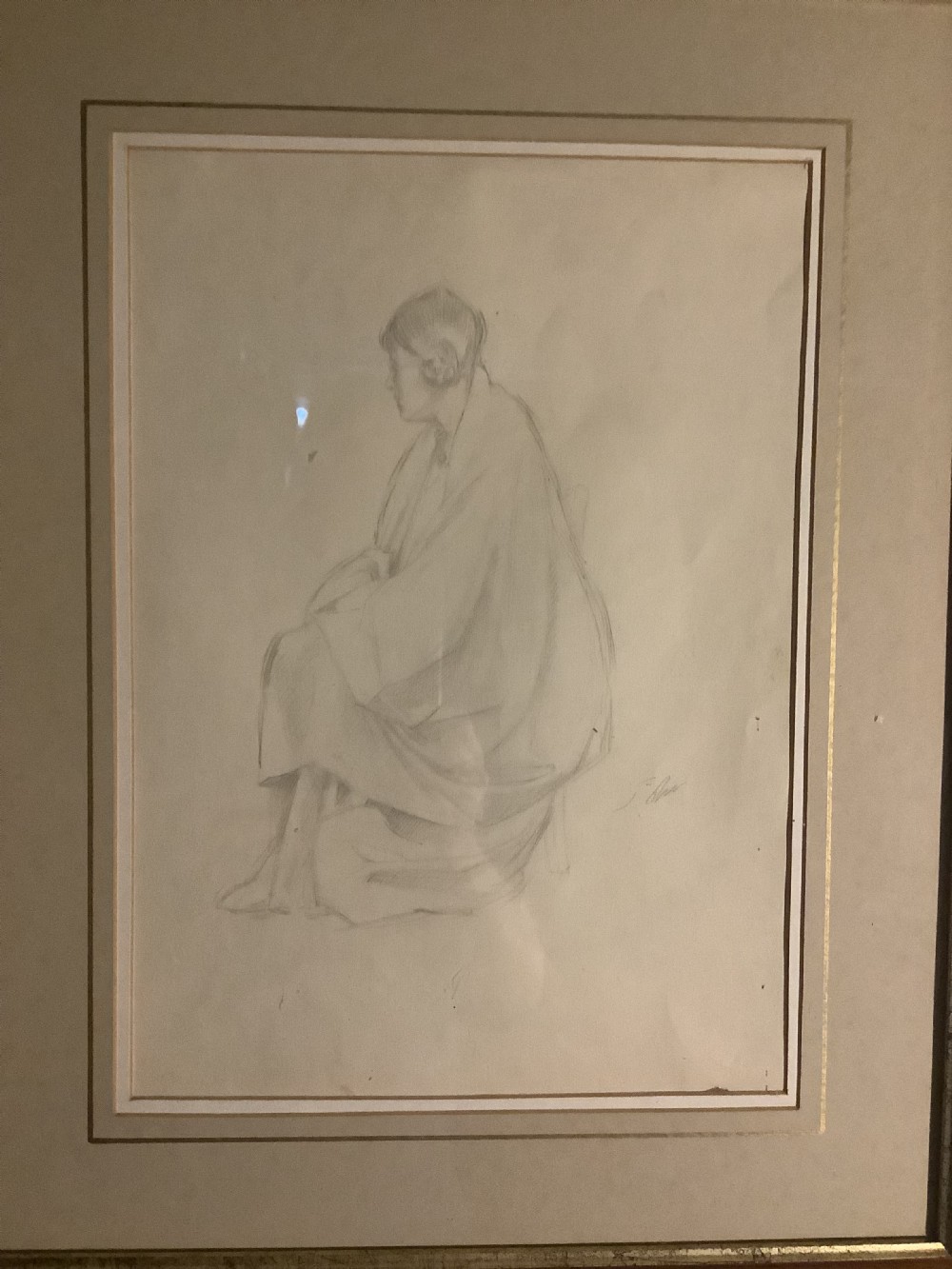 A framed monochrome pencil sketch depicting a seated draped female figure, presented in a neutral double mount within a moulded wooden frame. View II