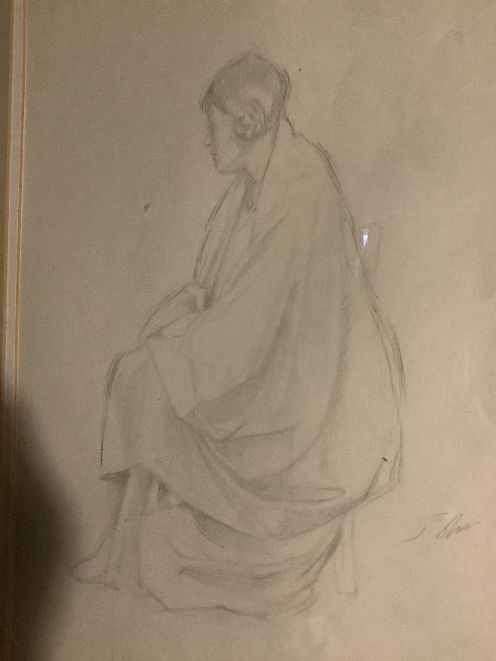 A framed monochrome pencil sketch depicting a seated draped female figure, presented in a neutral double mount within a moulded wooden frame. View III