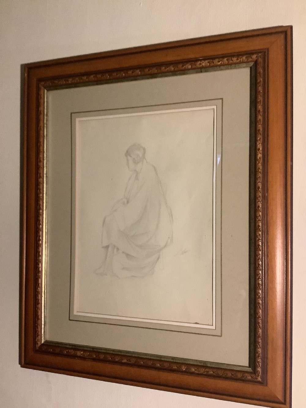 A framed monochrome pencil sketch depicting a seated draped female figure, presented in a neutral double mount within a moulded wooden frame. View VI