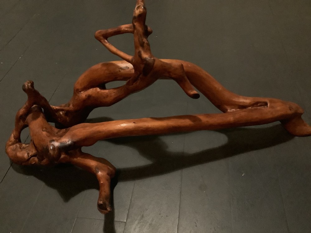 A polished yew wood sculpture featuring organic, intertwined smooth branches with a rich golden-amber tone. View III