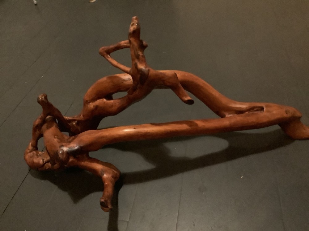 A polished yew wood sculpture featuring organic, intertwined smooth branches with a rich golden-amber tone. View VI