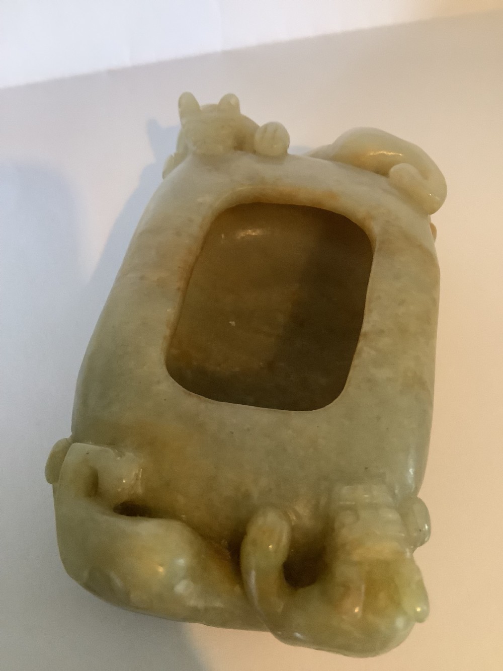 A hollowed pale green jade brush washer featuring high-relief dragon carvings along the outer edges and natural russet undertones. View VIII