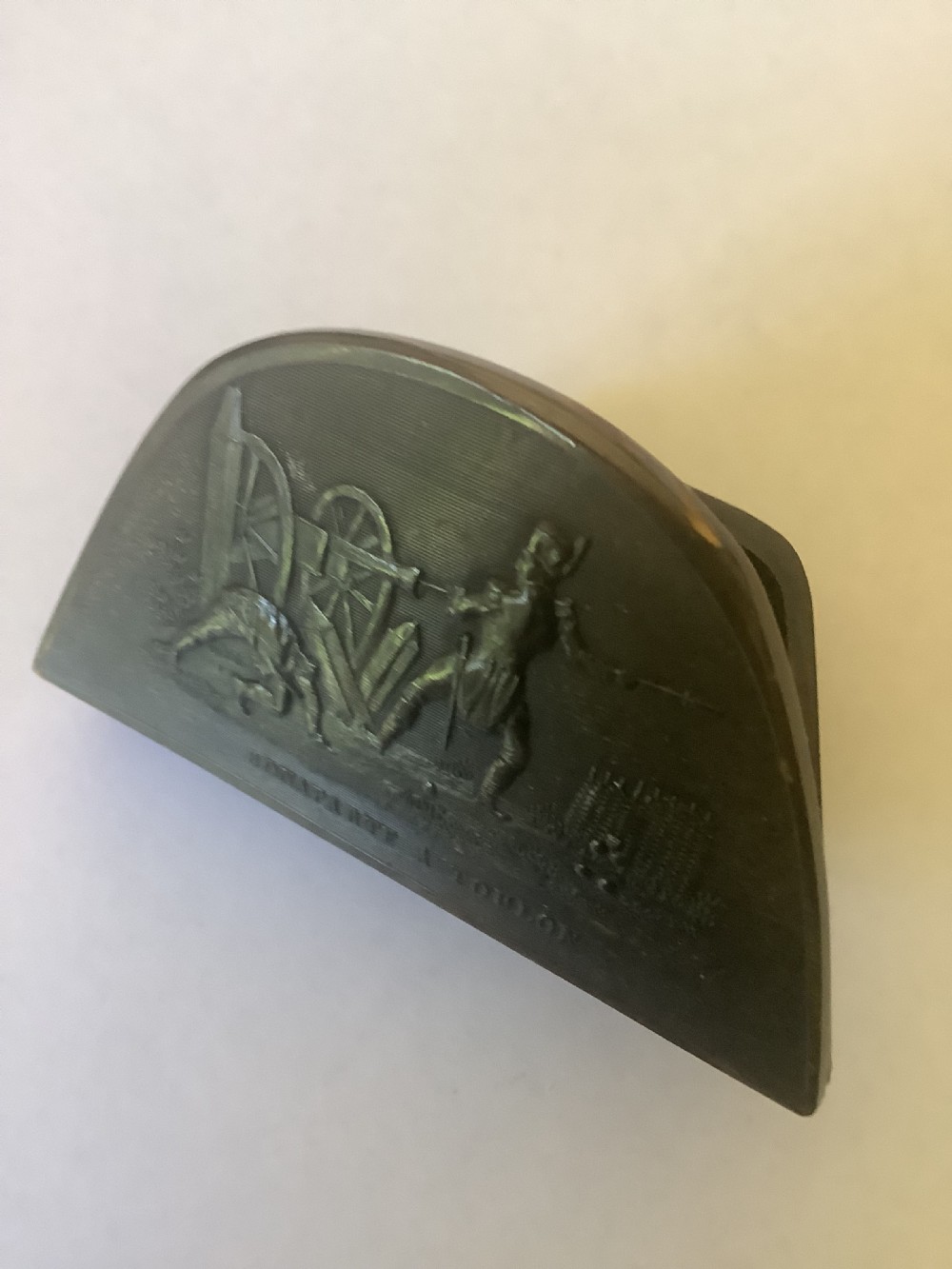A dark brown pressed horn snuff box shaped like a bicorn hat with a relief scene depicting Napoleon at Toulon. View VI