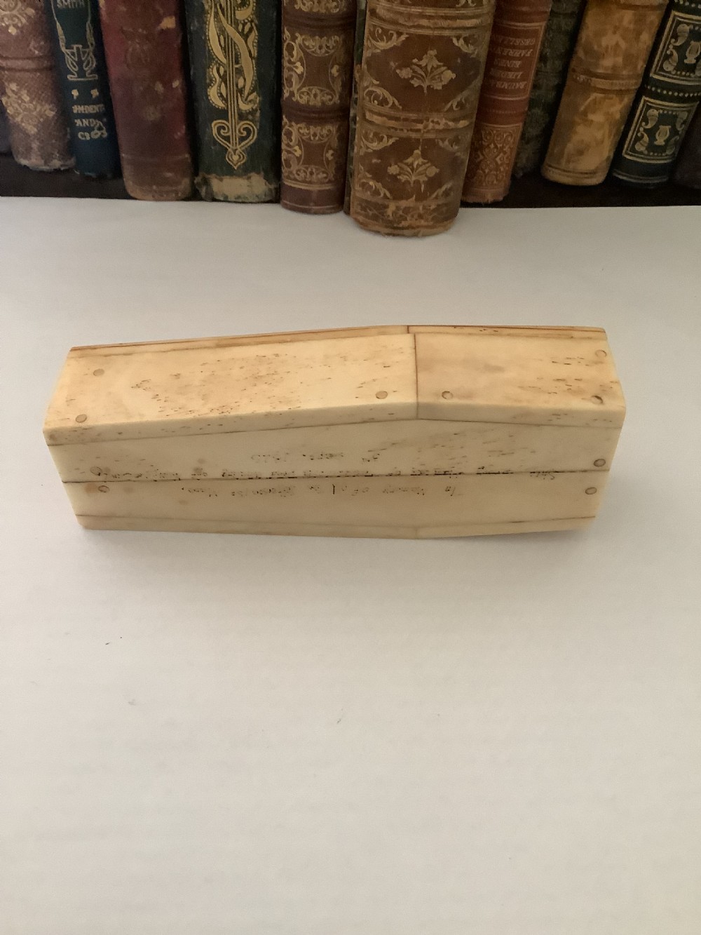 A cream-coloured bone coffin box featuring etched scrimshaw depictions of a whaling scene, boats, and ocean waves on the lid. View IV