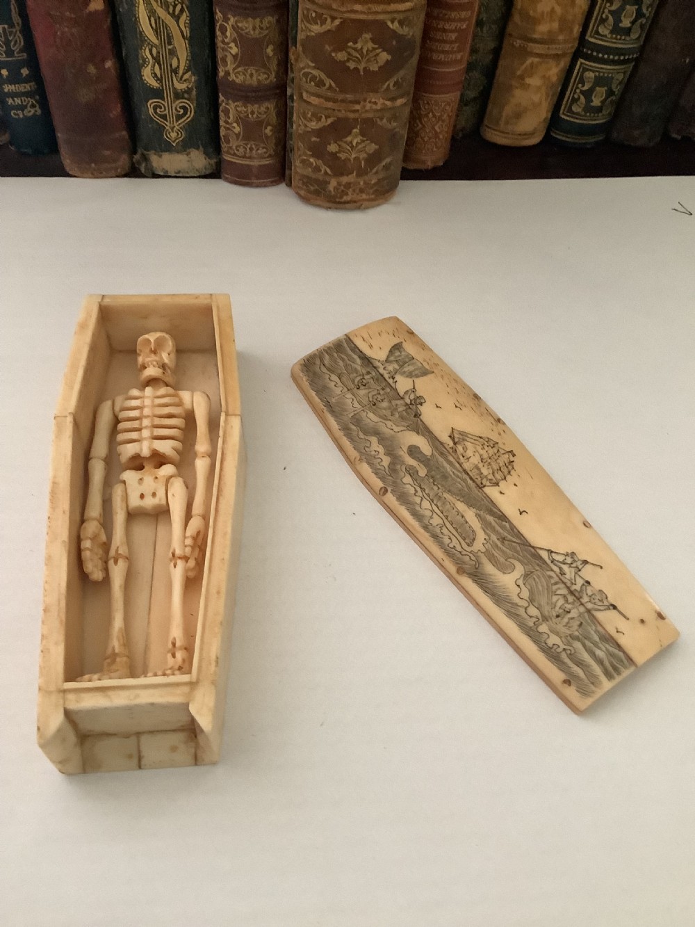 A cream-coloured bone coffin box featuring etched scrimshaw depictions of a whaling scene, boats, and ocean waves on the lid. View VII