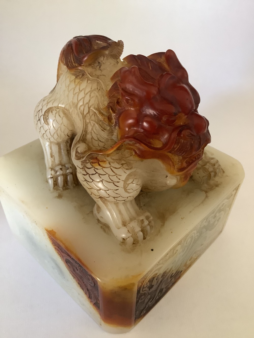 A carved cream and russet jade-style Chinese desk seal featuring a detailed guardian lion finial atop a square base. View III