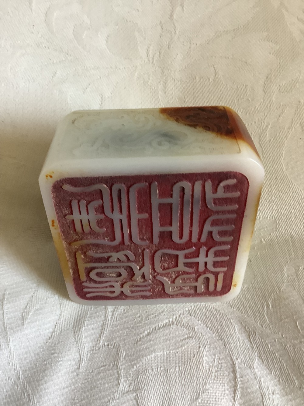 A carved cream and russet jade-style Chinese desk seal featuring a detailed guardian lion finial atop a square base. View VIII