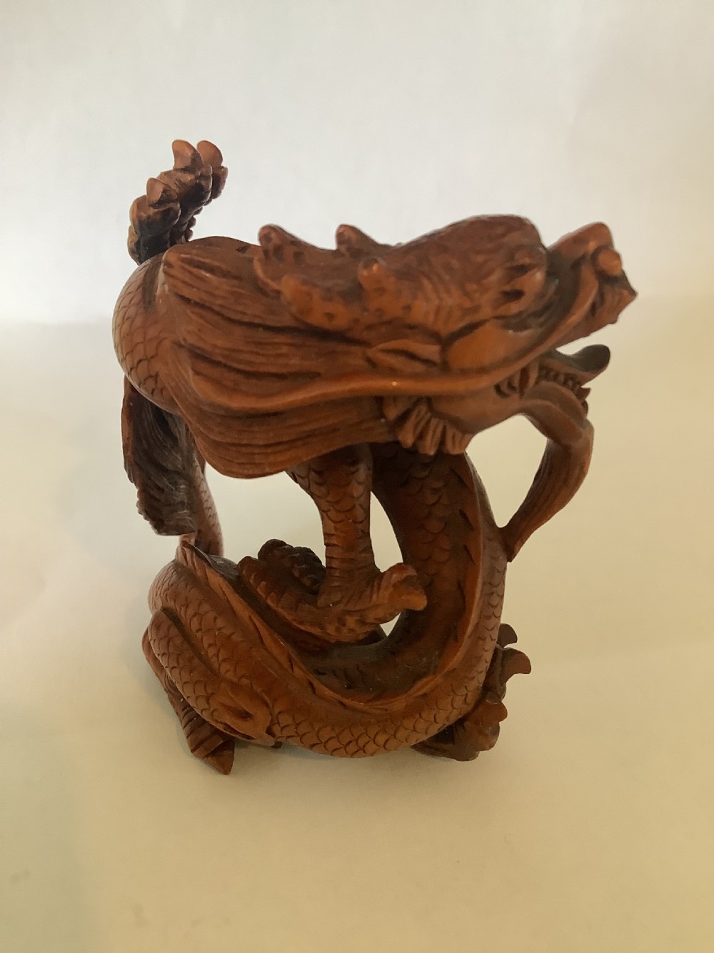 A finely detailed Japanese boxwood carving depicting a coiled dragon with an open mouth and carved scales. View II