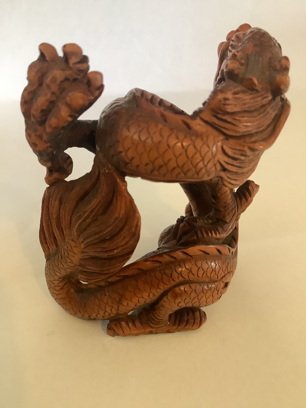 A finely detailed Japanese boxwood carving depicting a coiled dragon with an open mouth and carved scales. View VII