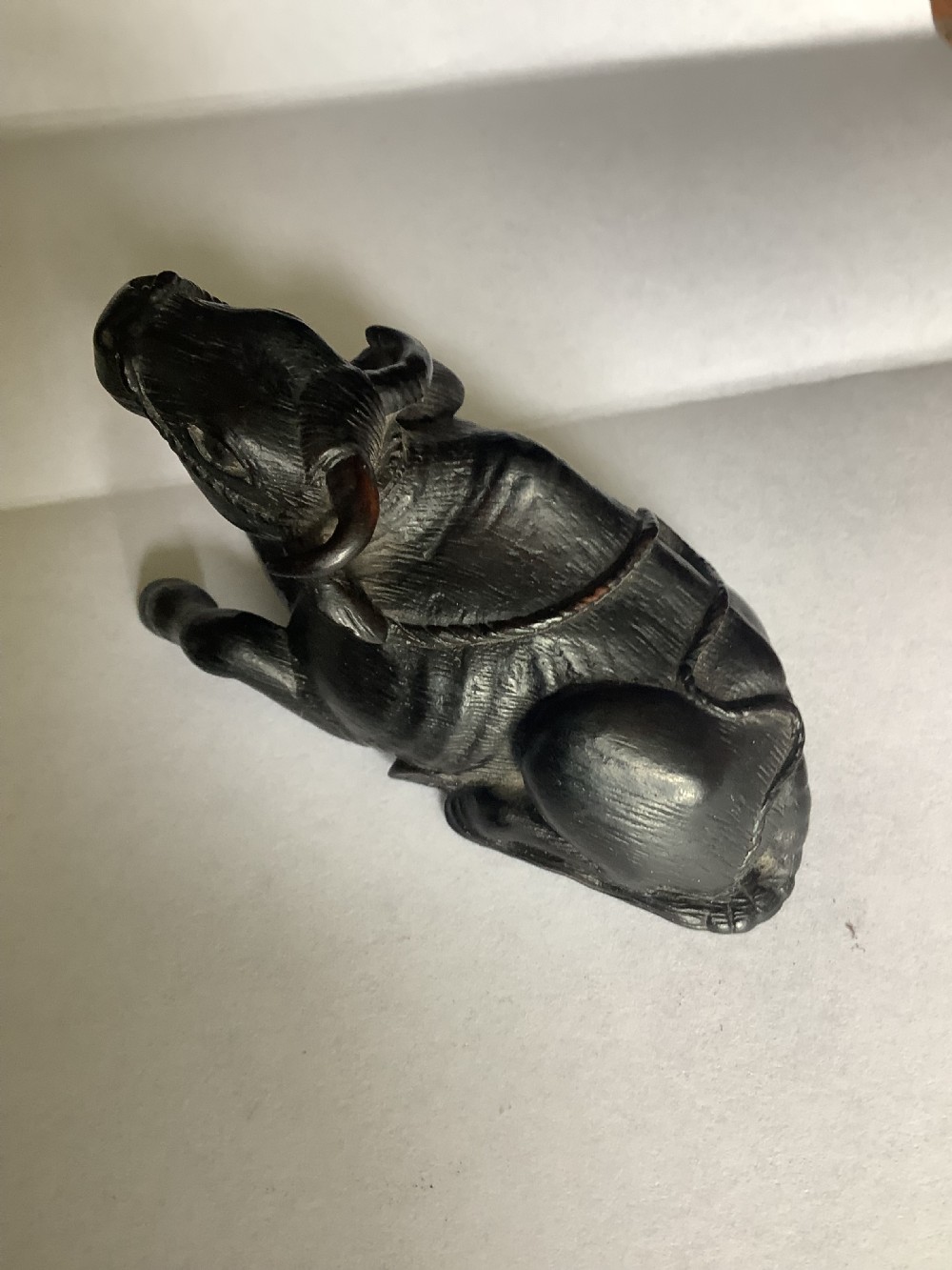 A dark carved wooden Japanese netsuke depicting a recumbent water buffalo with curved horns and hair detail. View IV