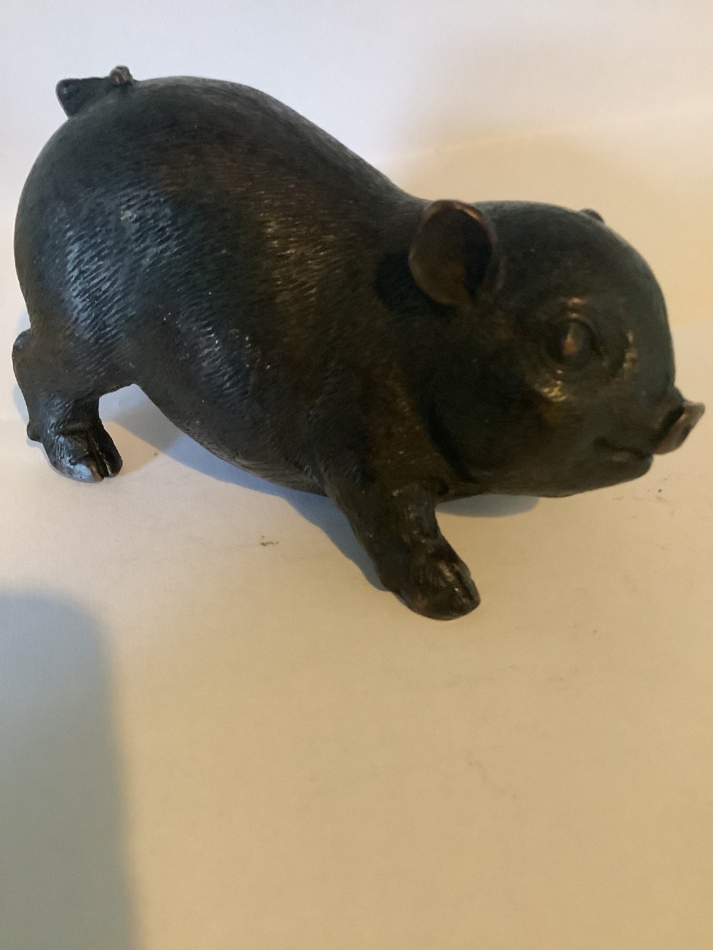 A 19th-century Chinese cast bronze figure of a pig with detailed incised hair texture and a dark brown patinated surface. View V