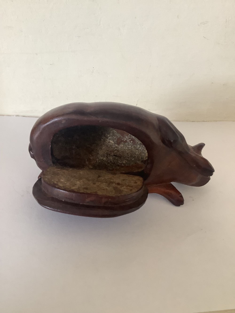 A hand-carved wooden snuff box sculpted in the form of a recumbent animal with a smooth brown finish. View IV