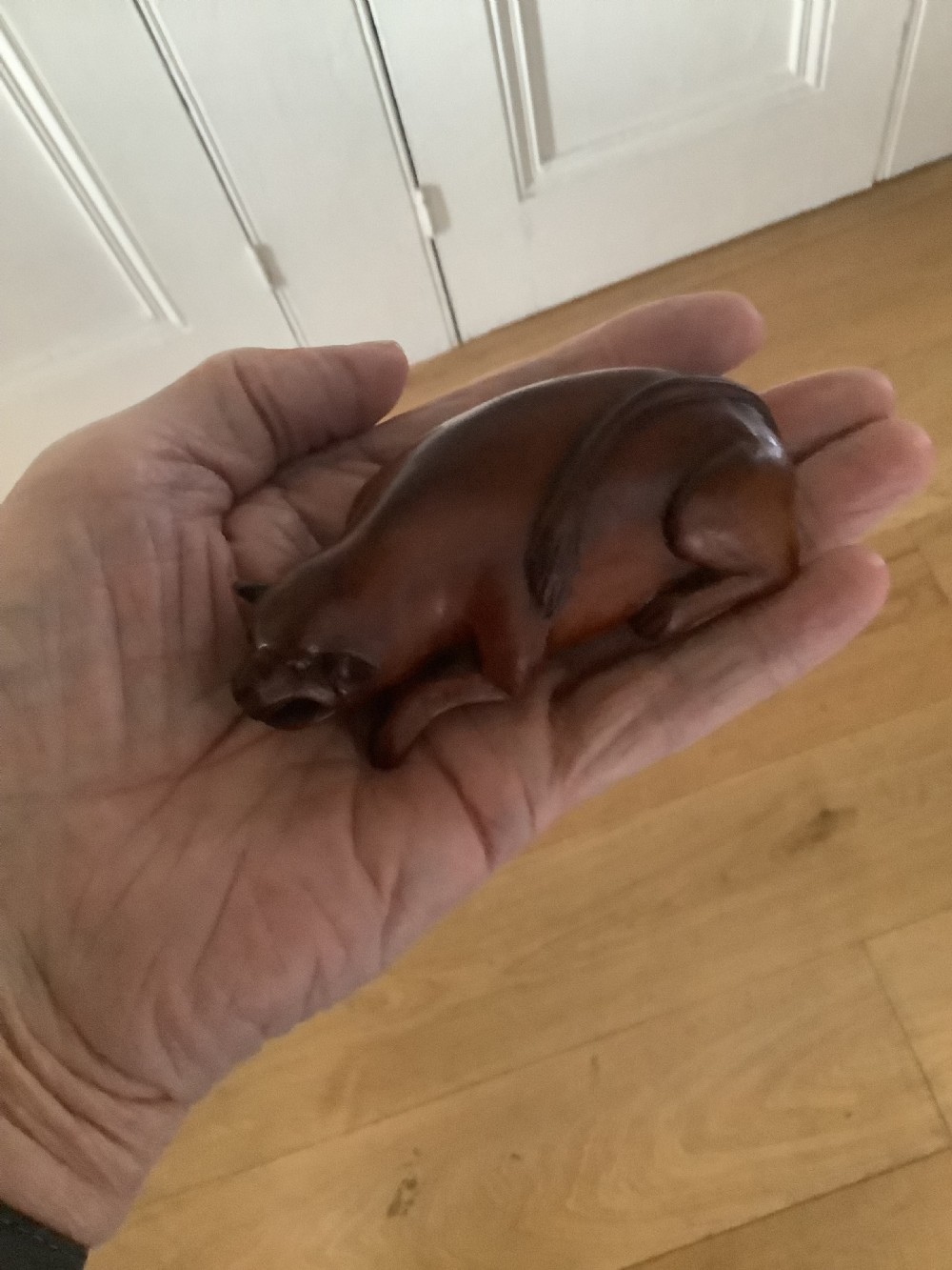 A hand-carved wooden snuff box sculpted in the form of a recumbent animal with a smooth brown finish. View V
