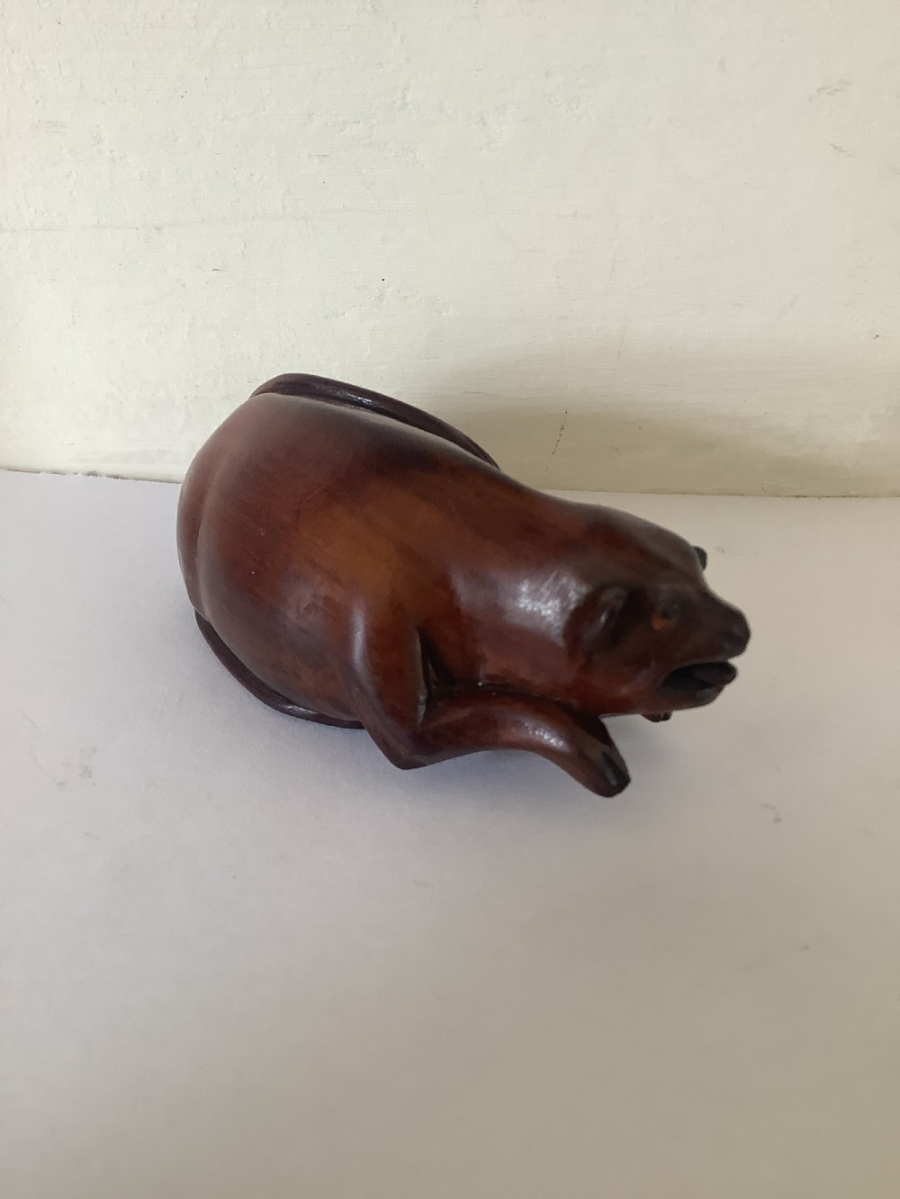 A hand-carved wooden snuff box sculpted in the form of a recumbent animal with a smooth brown finish. View VI