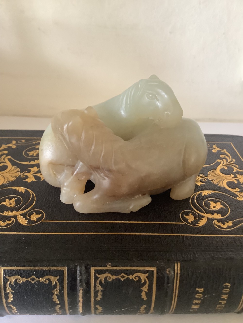 A hardstone carving depicting two recumbent horses crafted in pale celadon green stone. View IV