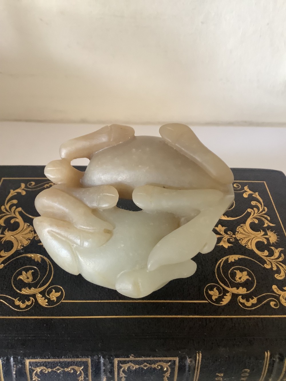 A hardstone carving depicting two recumbent horses crafted in pale celadon green stone. View VI